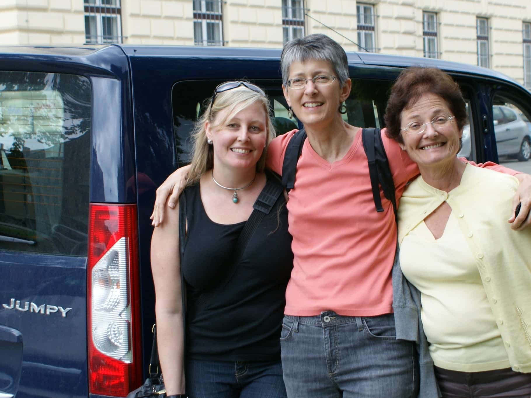 Going on a trip with your girl or guy friends to do something is a great gift as evidenced by the big smiles on three women in front of a van.