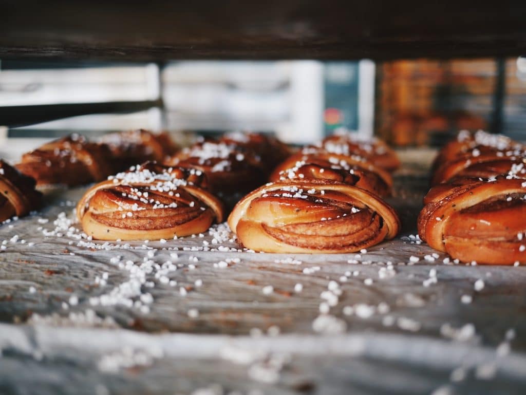 Swedish cinnamon buns sprinkled with sugar make a delicious treat paired with an afternoon coffee when traveling.