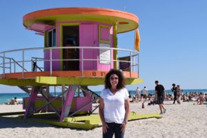 woman in front of deco lifeguard station on Miami"s South Beach, an '80's destination that's still popular today.