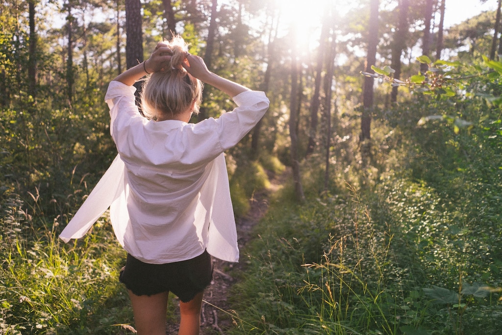 Woman in white shirt, a travel wardrobe essential, in the woods