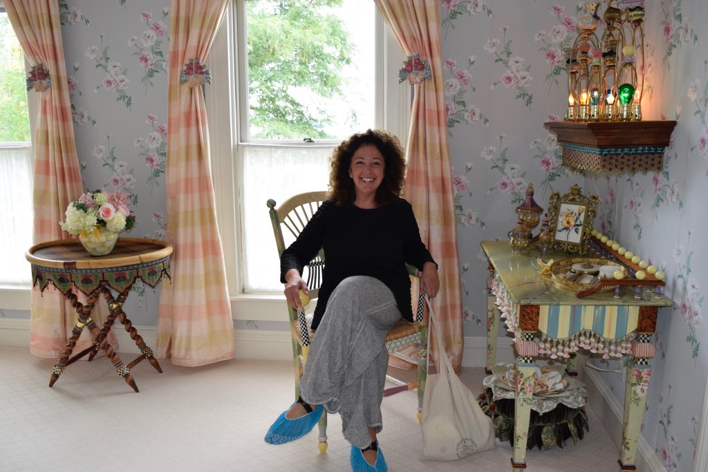 woman in Mackenzie-Childs farmhouse bedroom