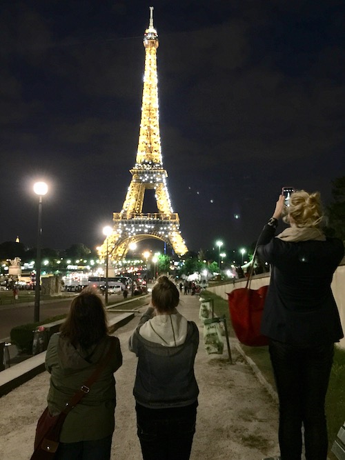 The Eiffel Tower in Paris at night, a popular summer family bucket list destination.