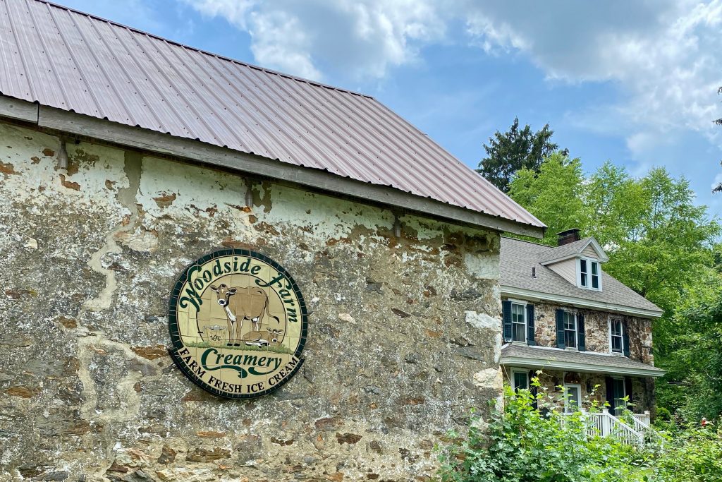 natural stone wall with logo for Woodside Creamery, a homemade ice cream stand in Delware, one of the fun things to do