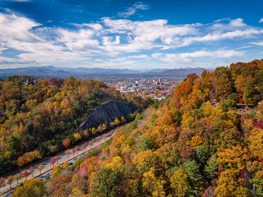 Fall mountain foliage with Asheville's skyline in the background on a weekend getaway