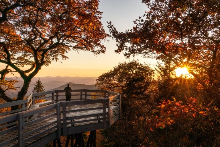 solo figure at a mountain overlook at sunset in Asheville with fall foliage